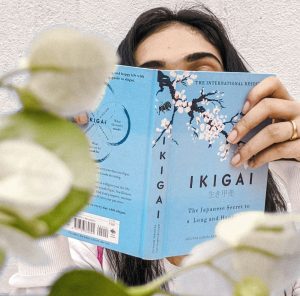 une femme lit une livre sur l'ikigai