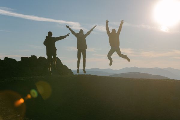 trois personnes dans la nature qui sautent de joie
